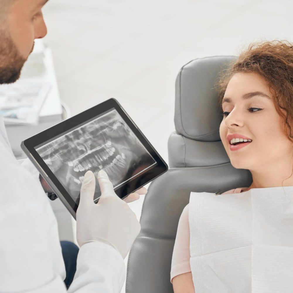 skilled-male-dentist-showing-x-ray-picture-teeth-woman skilled-male-dentist-showing-x-ray-picture-teeth-woman